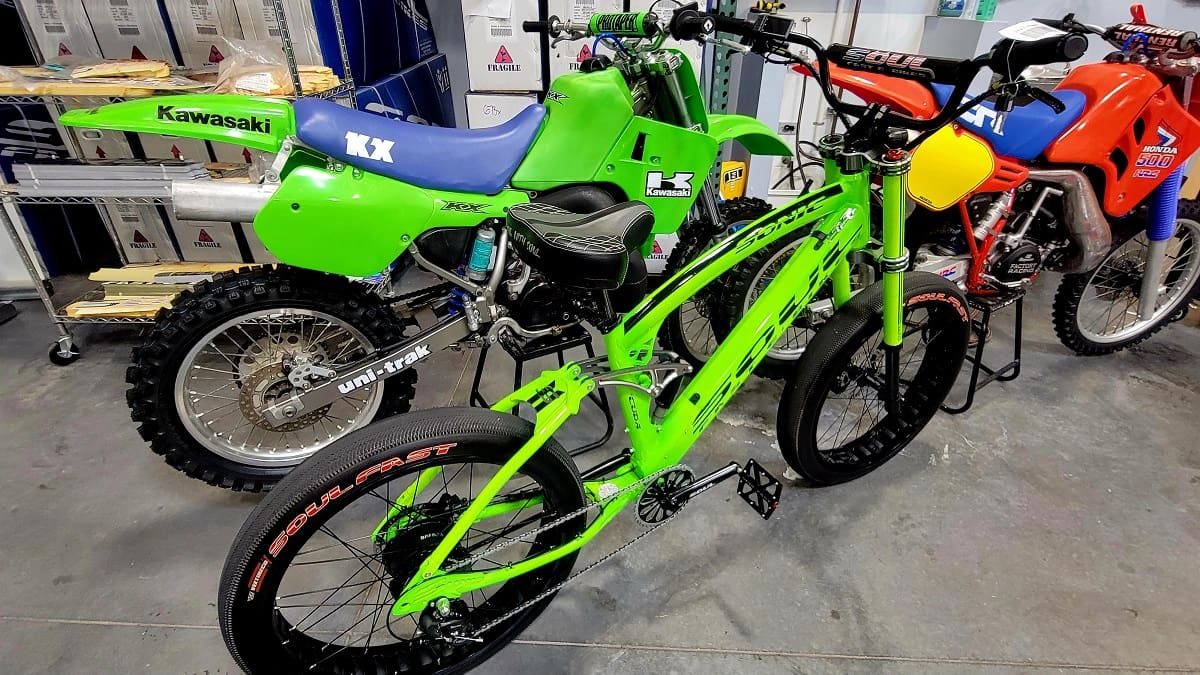 Green bicycle and motorcycles in a garage.