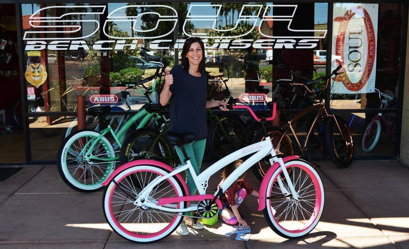 Woman with bicycle outside Soul Beach Cruisers.
