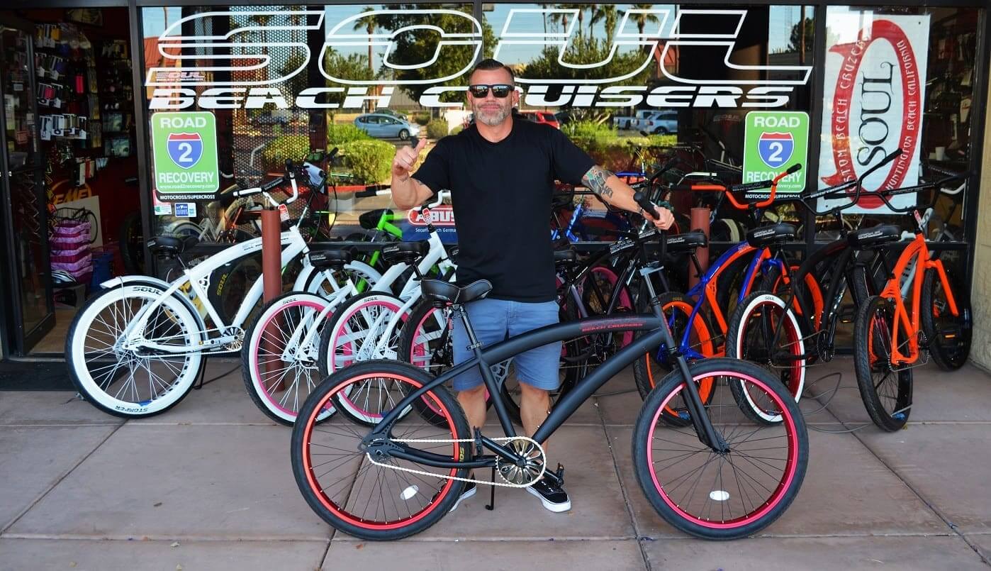 Man posing with custom beach cruiser bicycle.