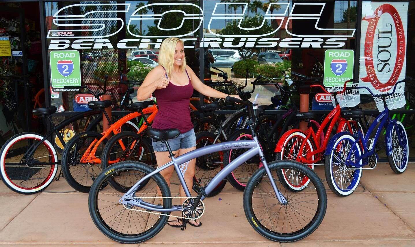 Woman posing with stylish beach cruiser bicycle.