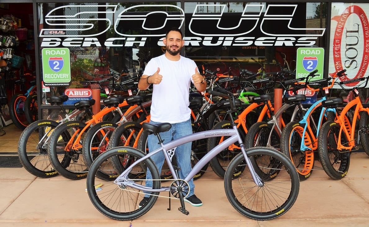 Man smiling with bike in store.