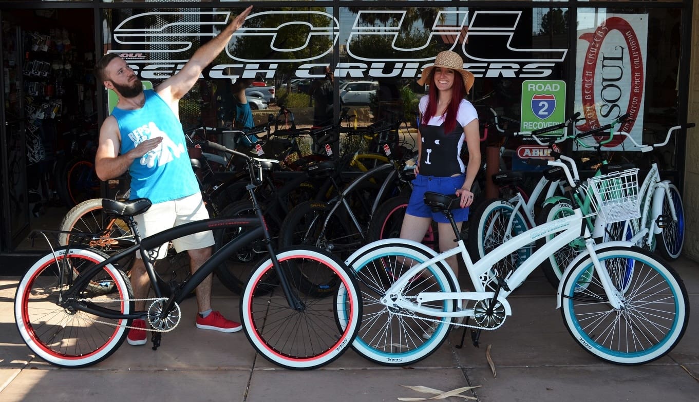People posing with beach cruiser bicycles.