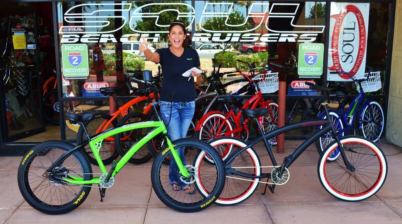 Person with bicycles outside a bike shop.