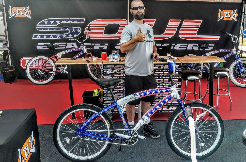 Man with bicycle at Soul Beach Cruisers booth.