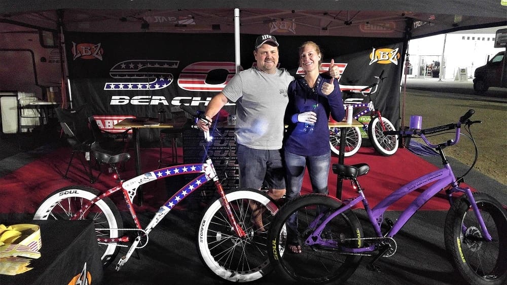 Man and woman posing with two bicycles.