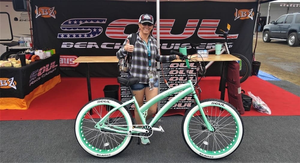 Person with bike at outdoor event booth.