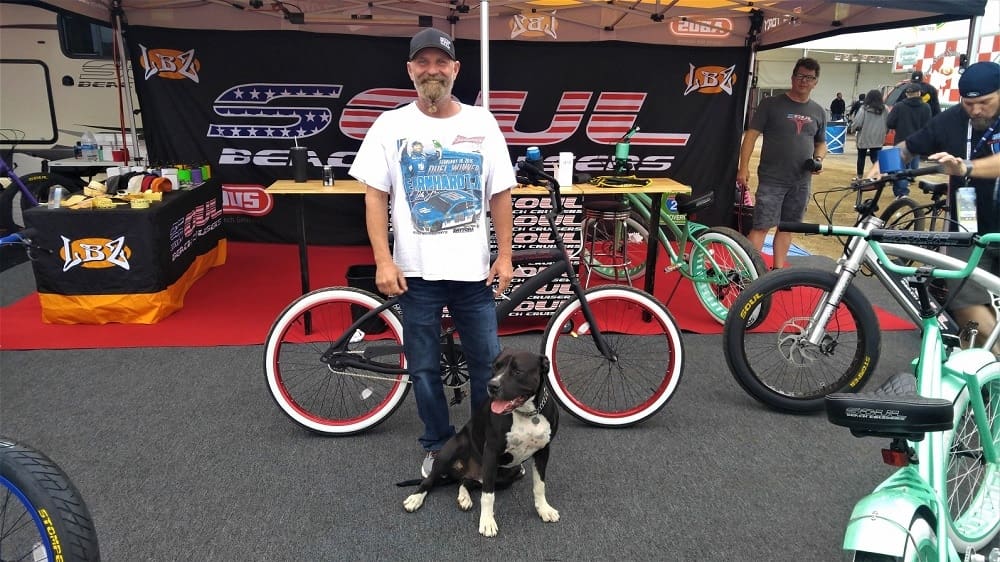 Man with dog at a bicycle booth.