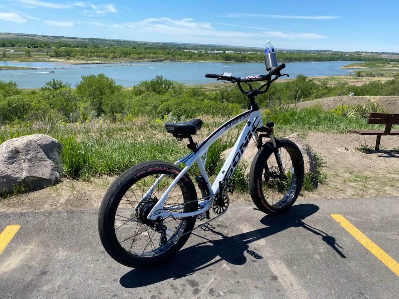 Electric bike parked near scenic lake view.
