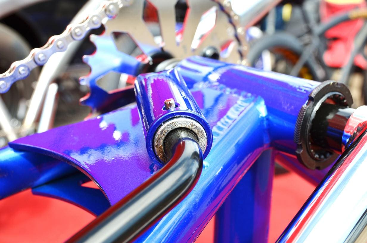 Shiny blue bike kickstand pivot close-up