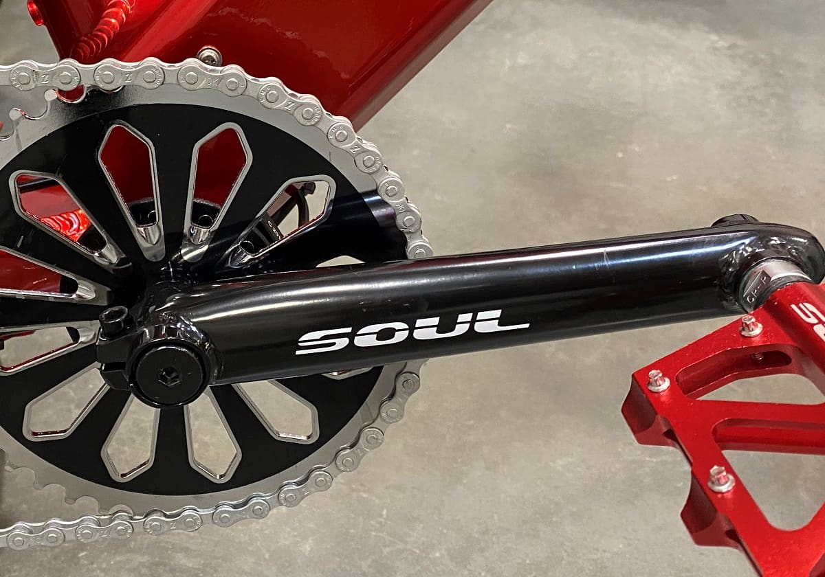 Red and black bicycle crankset with chain.