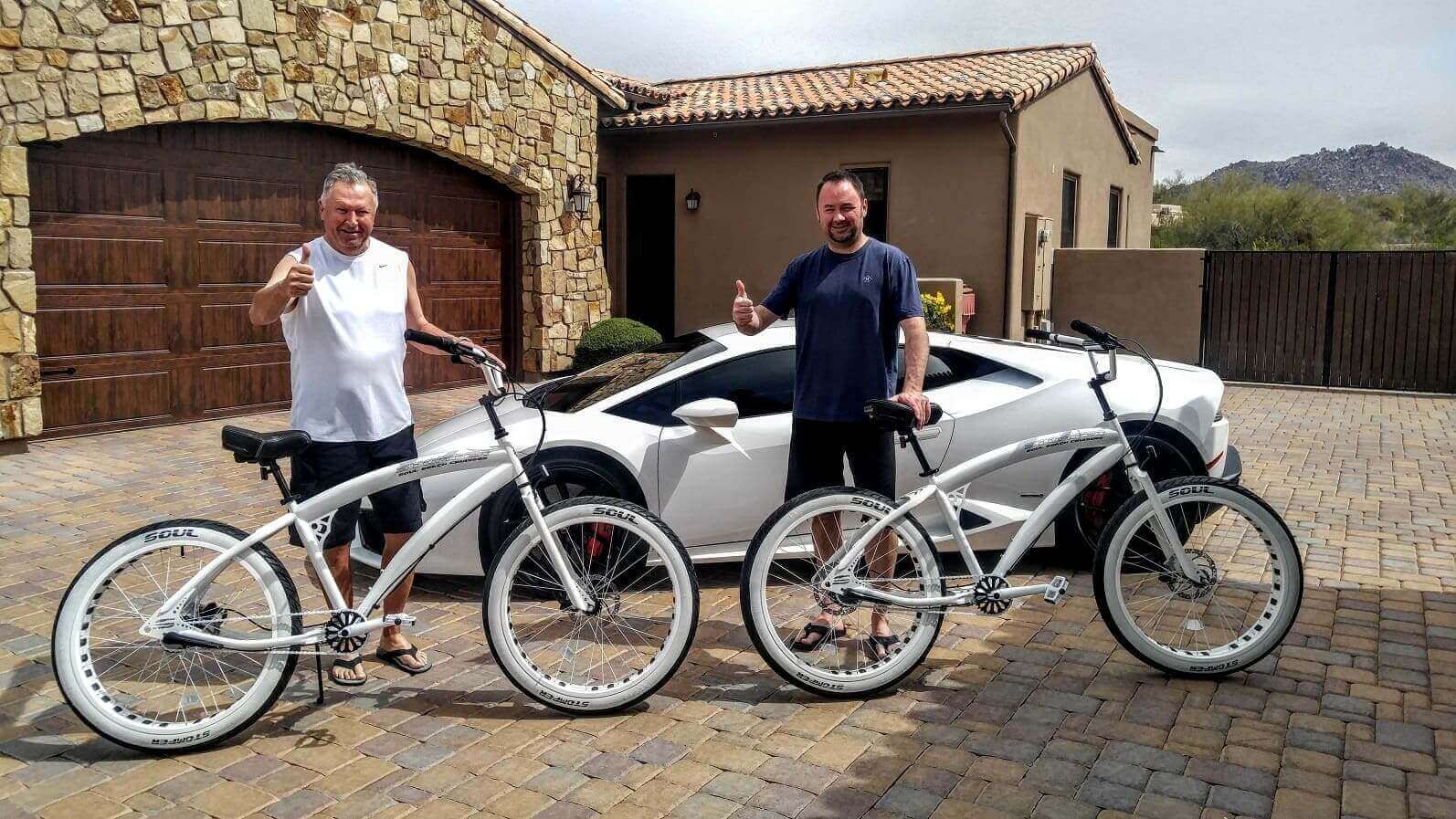 Two men with bikes, car, and house.