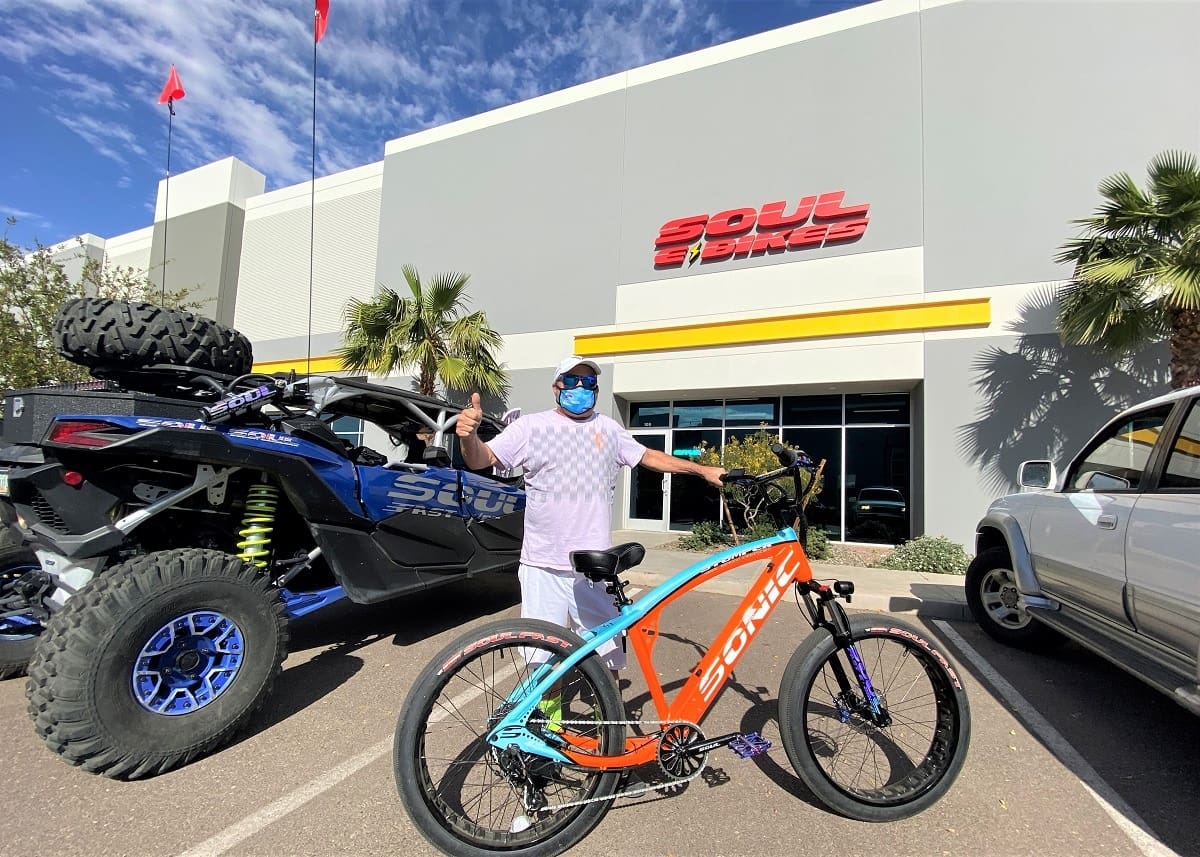 Person with bike outside Soul Bikes store.