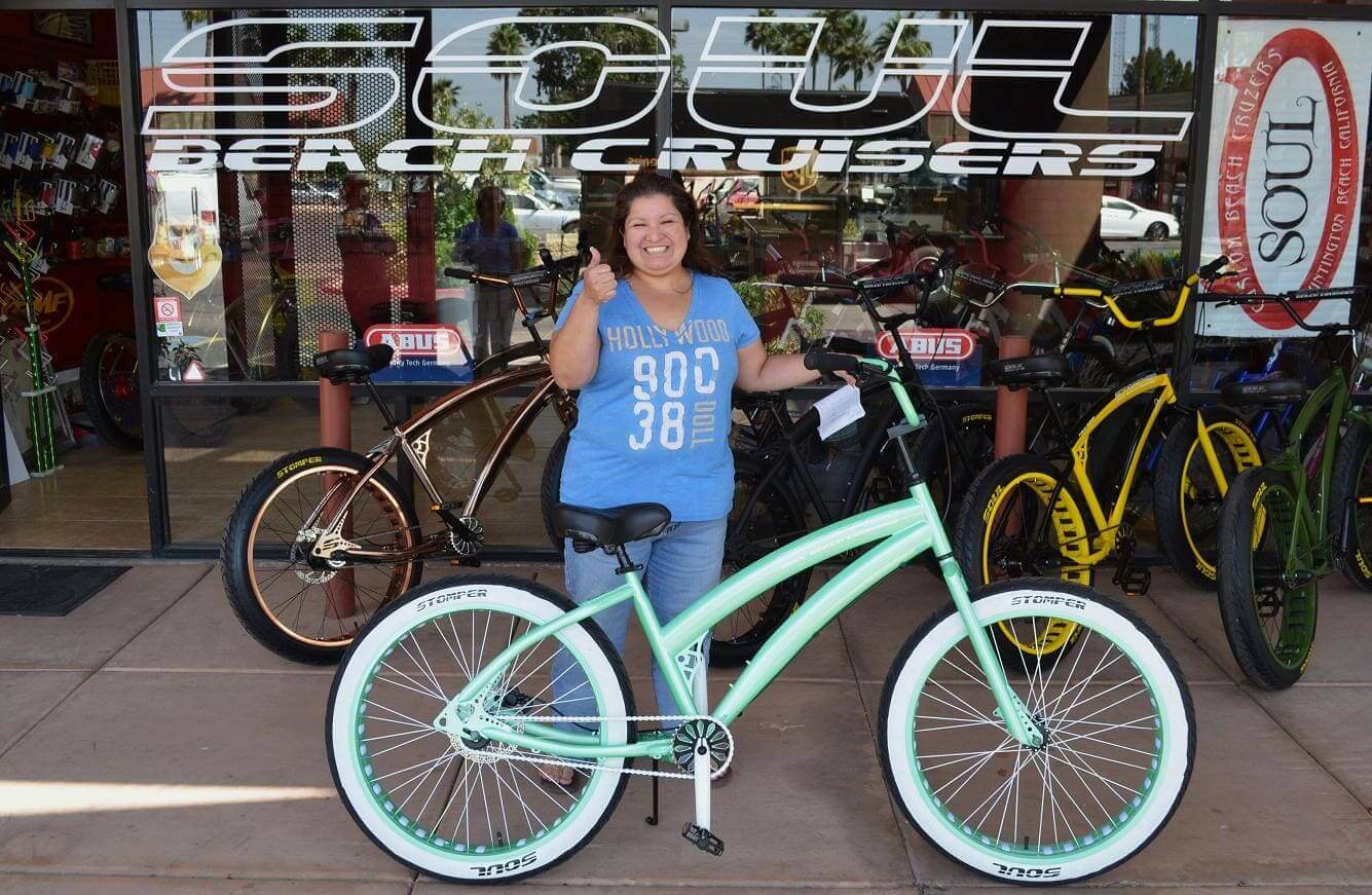 Woman smiling with mint green bicycle.