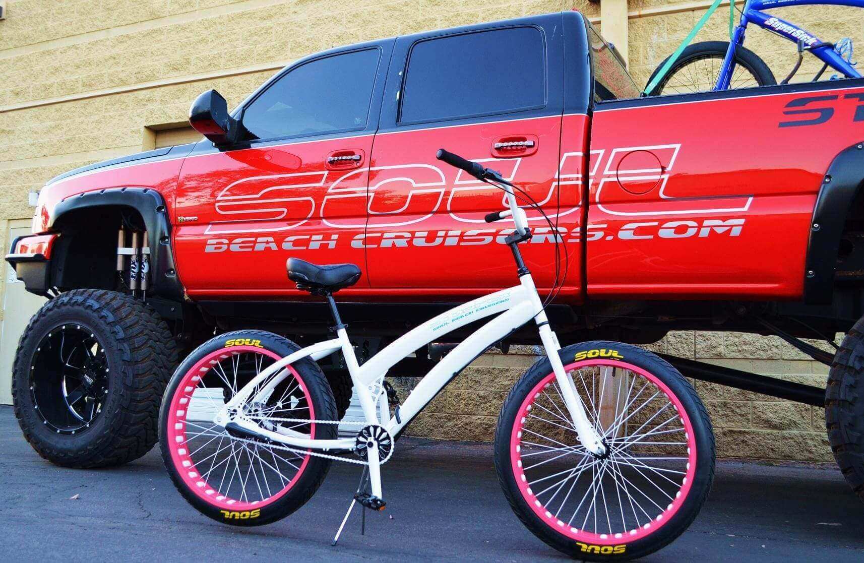 White bike in front of red truck.