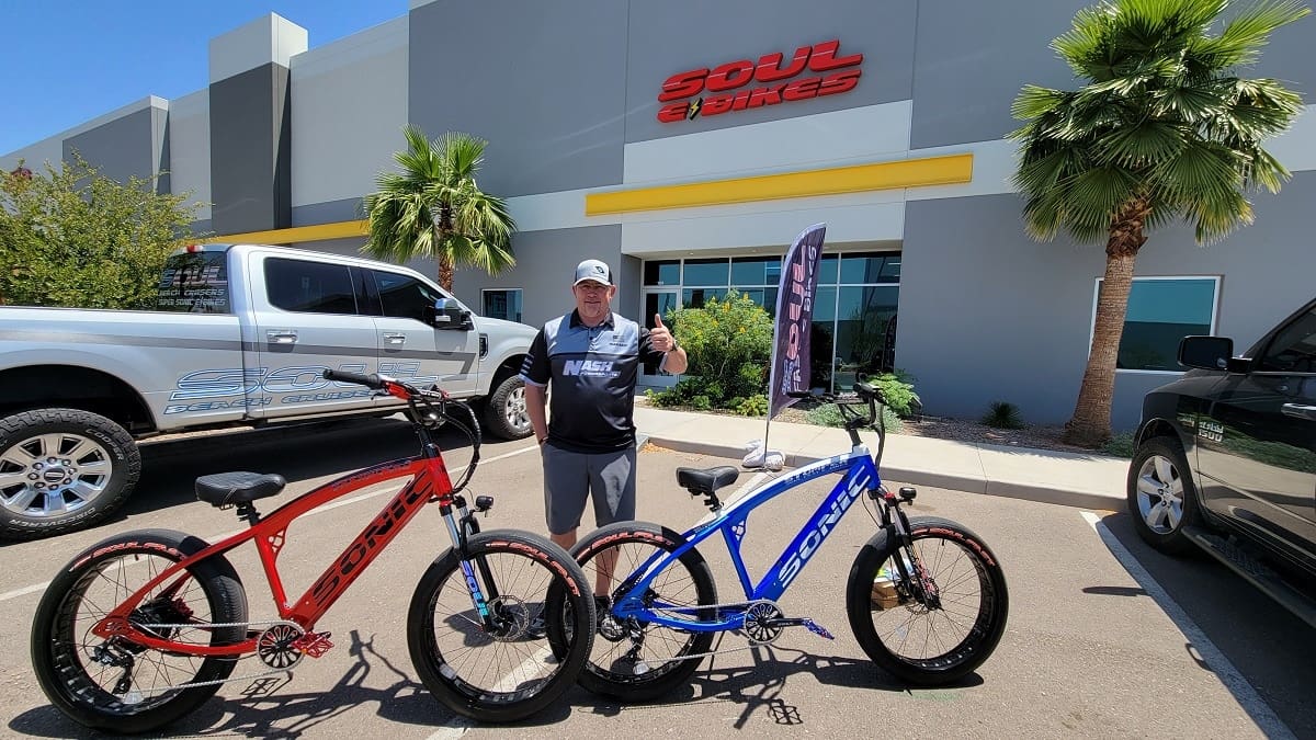 Man with electric bikes outside Soul eBikes store.