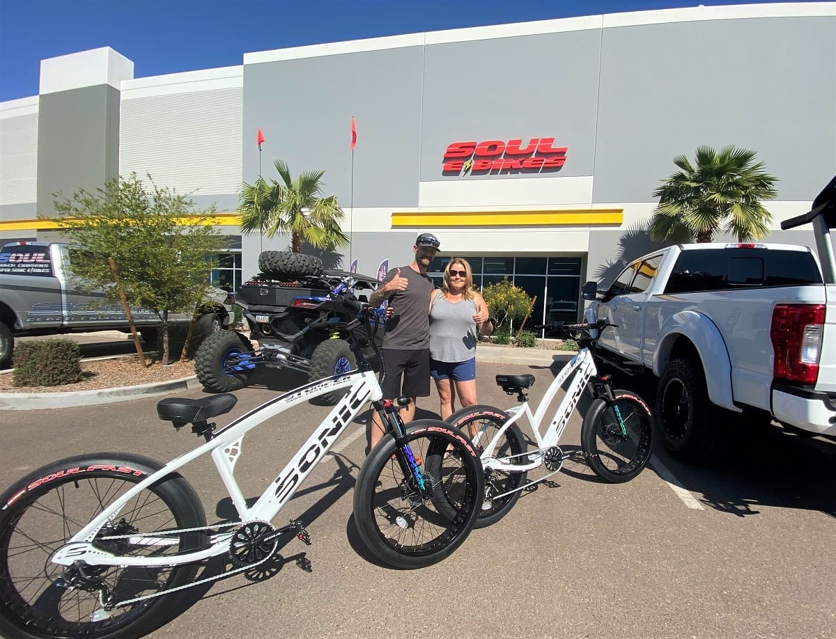 Couple with bicycles outside Soul Bikes store.