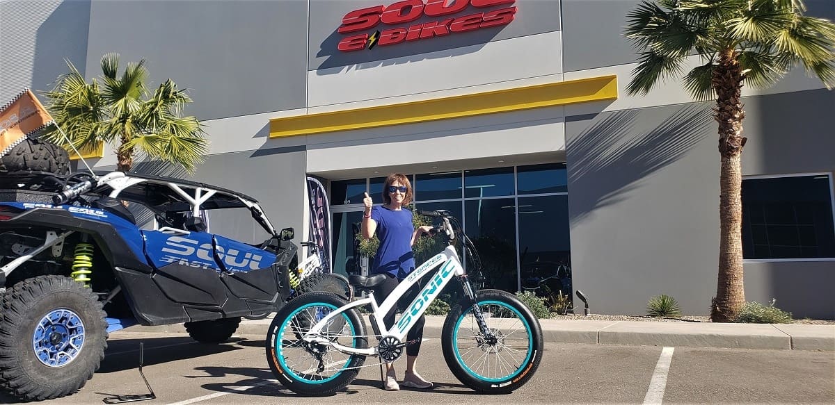 Person with e-bike outside a store.