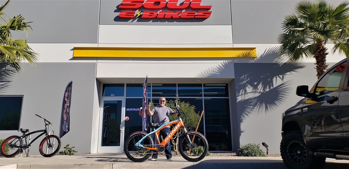 Man holding bike outside Soul Ebikes store.