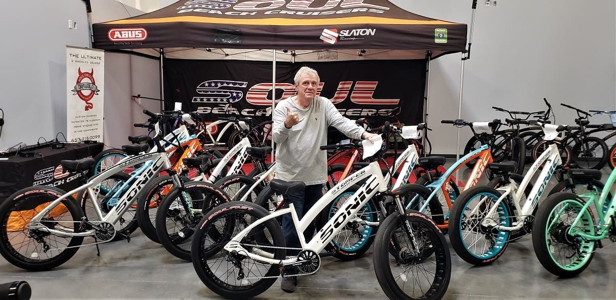 Man with electric bicycles in showroom.