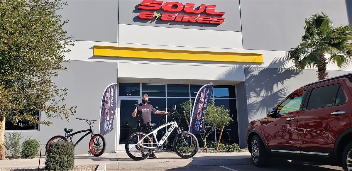 Man standing with bicycles outside Soul eBikes store.