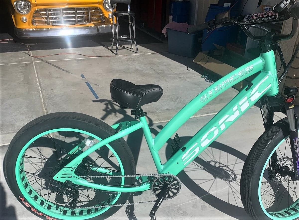 Mint green electric bike in a garage.