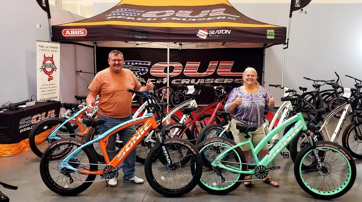 Man and woman with colorful bicycles display.