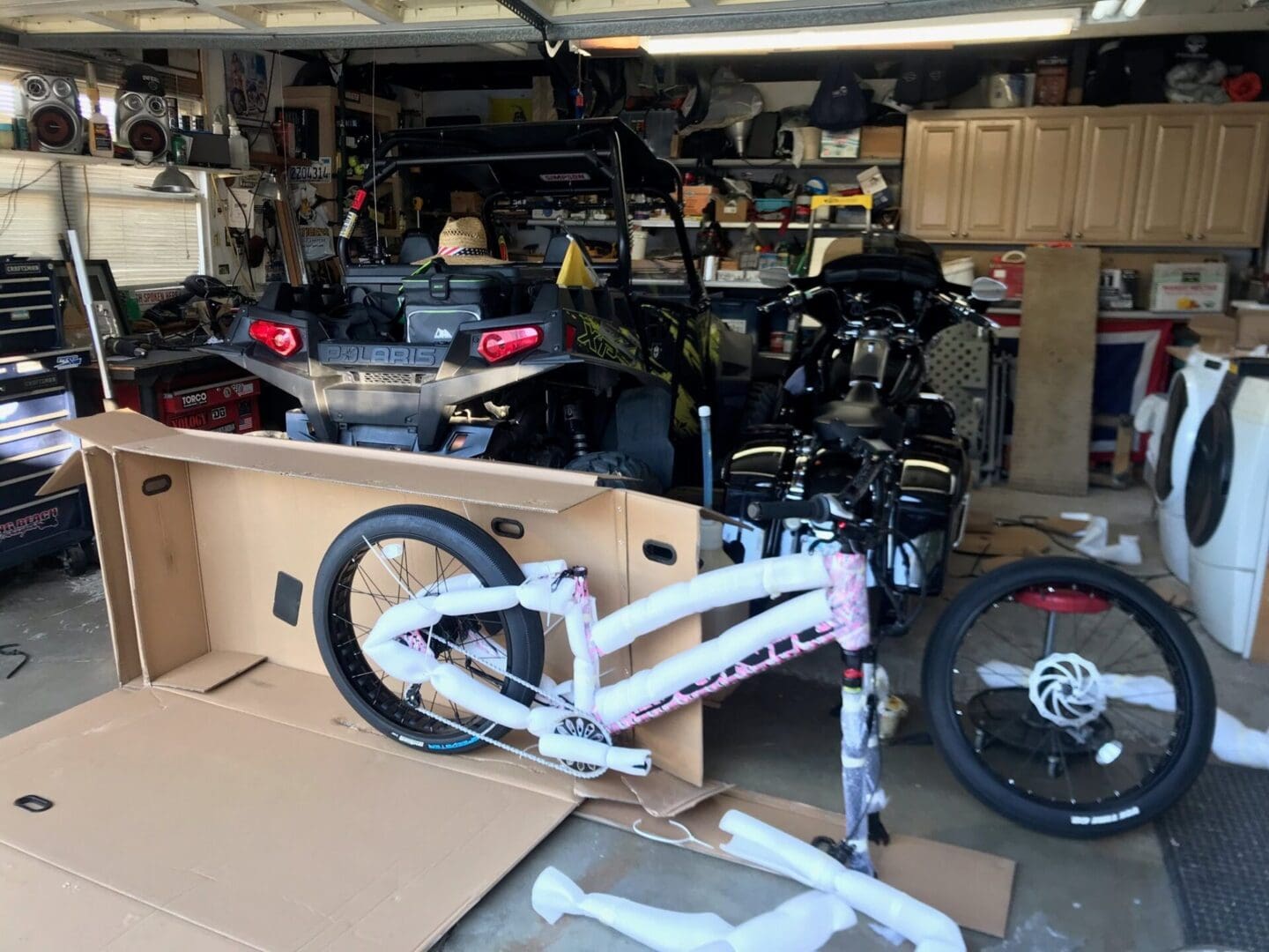 Unassembled bicycle in a cluttered garage.