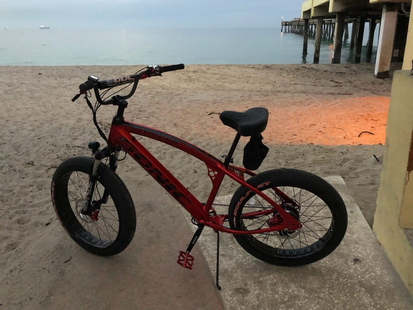 Red bicycle on a sandy beach.