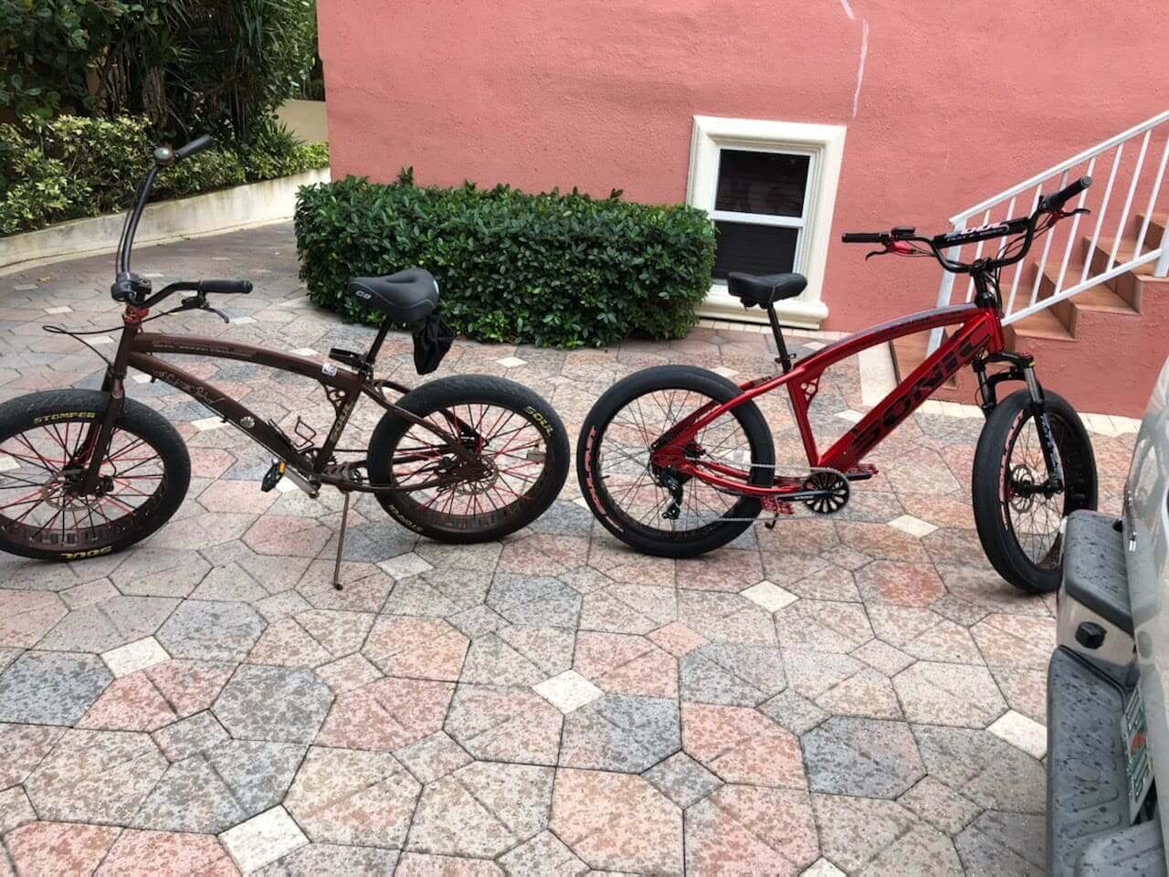 Two bicycles on a patterned driveway.