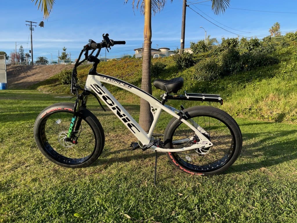 Electric bike on grassy landscape with trees.