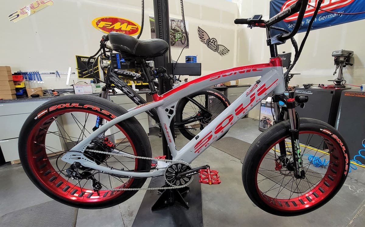 Red and white bicycle in workshop setting.