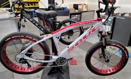 Red and white bicycle in a workshop.