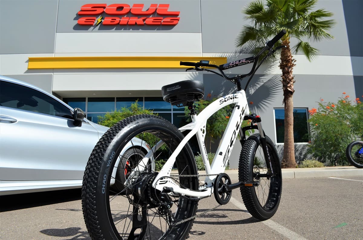 White bicycle parked outside Soul Bikes store.