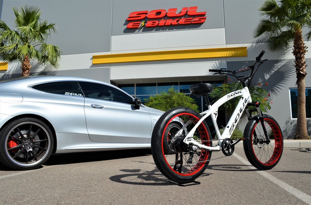White e-bike and car outside Soul eBikes.