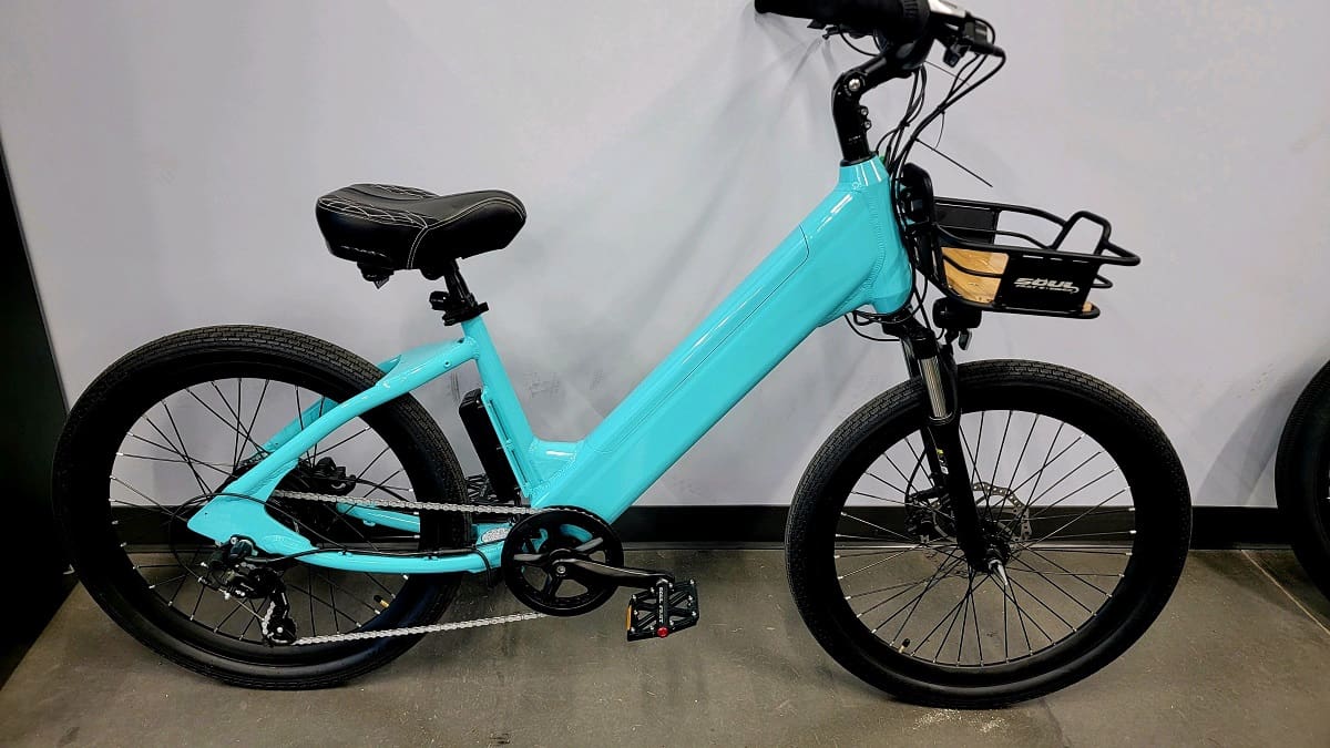 Teal electric bike with black basket.