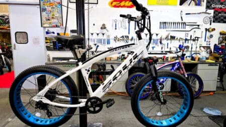 White bicycle on repair stand in workshop.