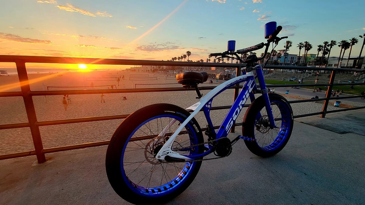 Bicycle on beachside promenade during sunset.