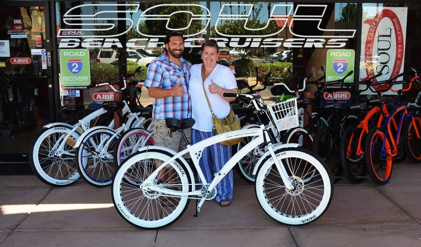 Couple with bicycles in front of store.