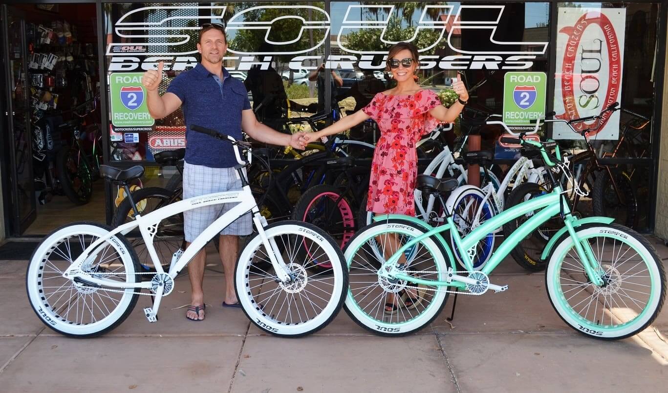 Couple holding hands with two bicycles outside.