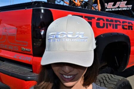 Person wearing hat in front of truck.