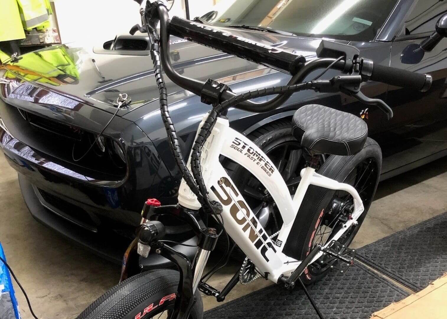 Bicycle parked in front of black car.