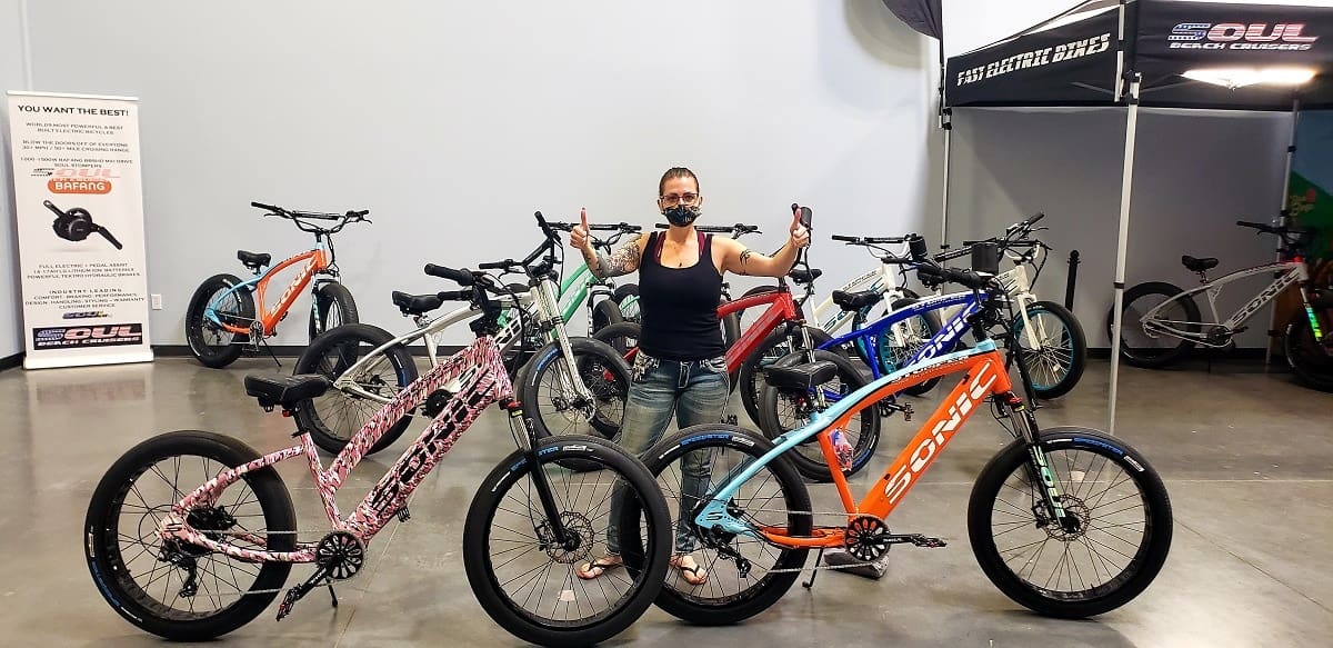 Person with electric bikes in showroom.