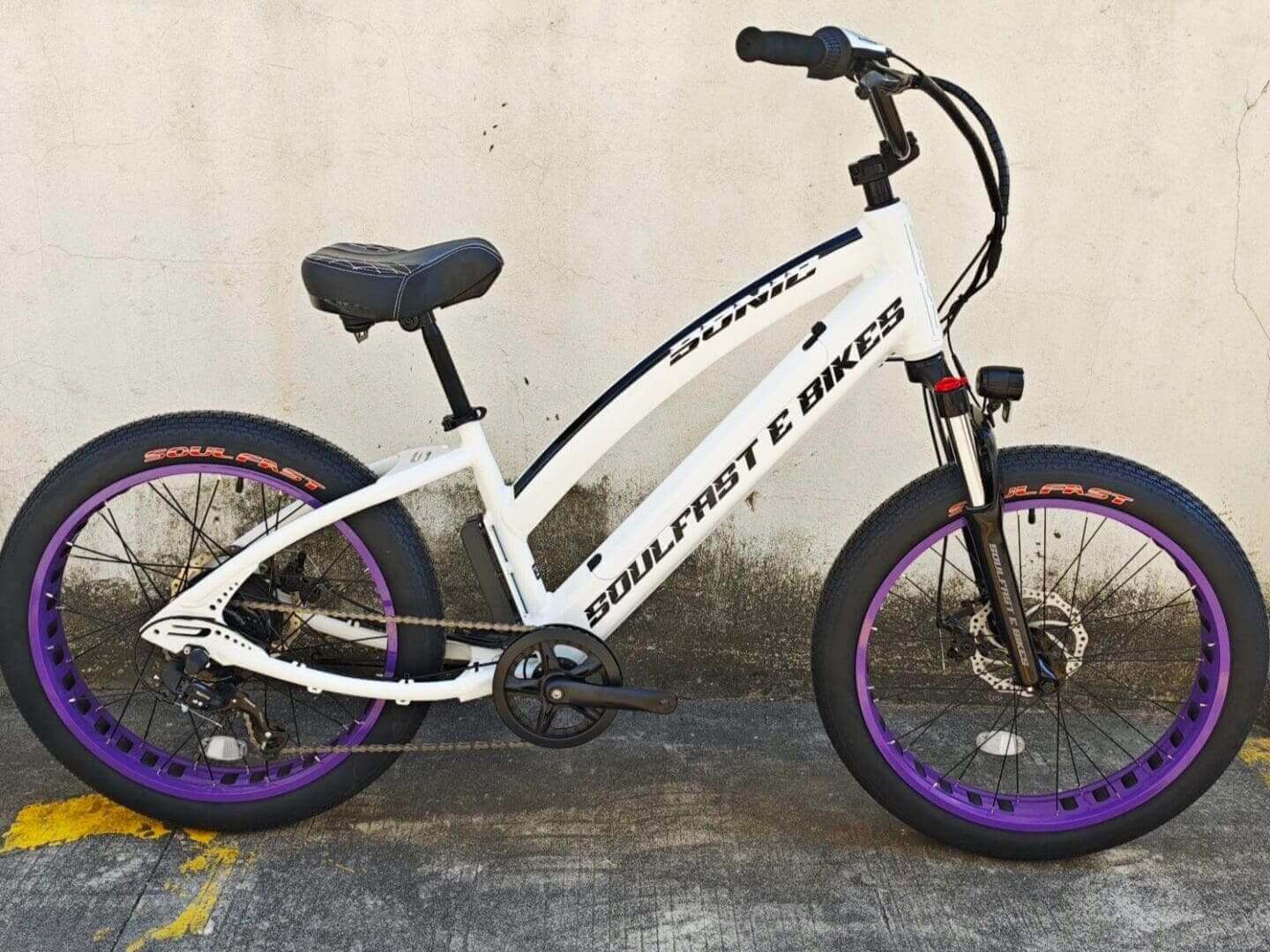 White cruiser e-bike with purple rims