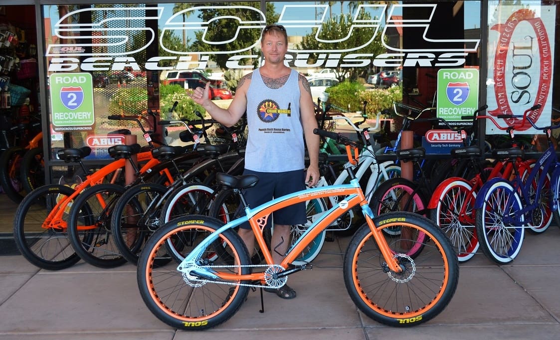 Man with custom orange and blue bicycle.