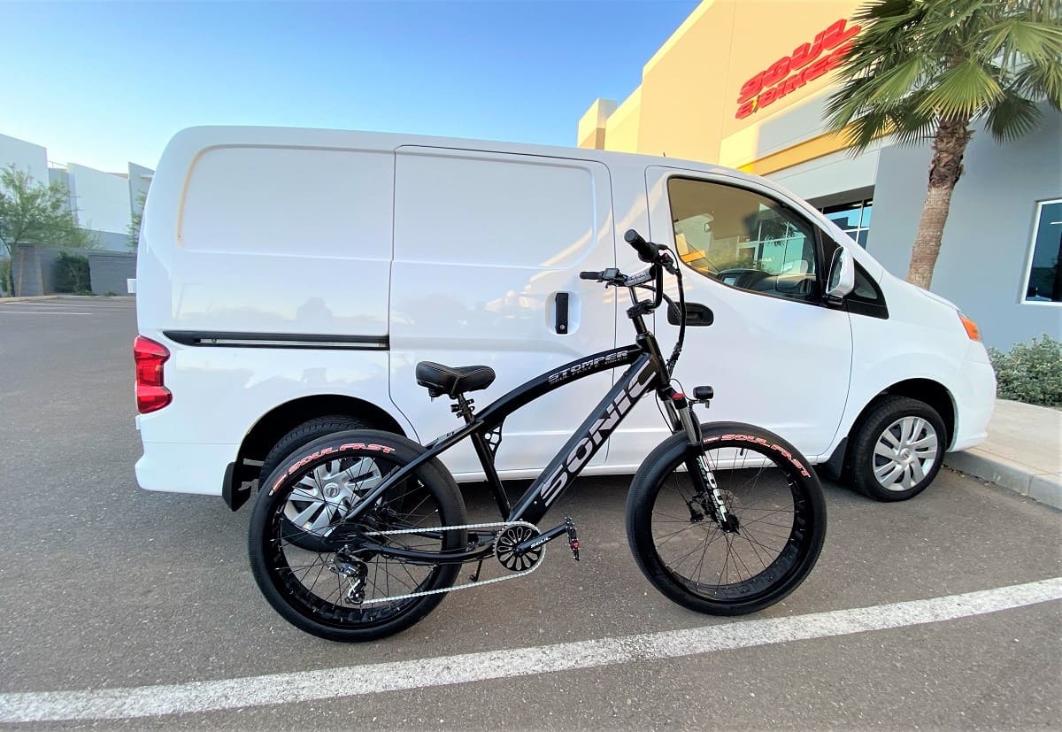 Bicycle parked beside a white van.