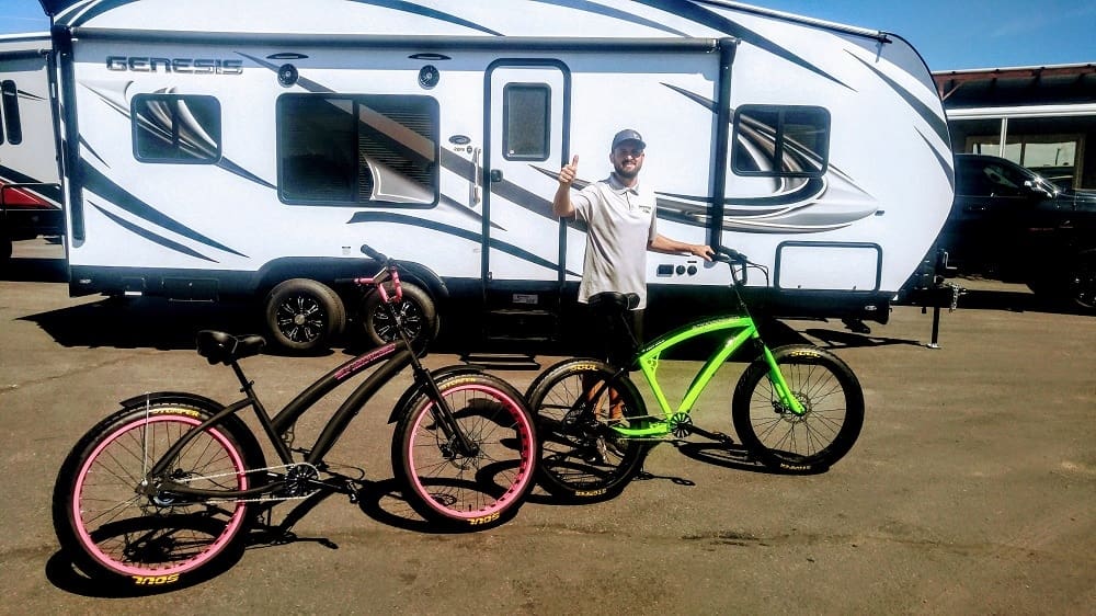 Man with bicycles in front of trailer.