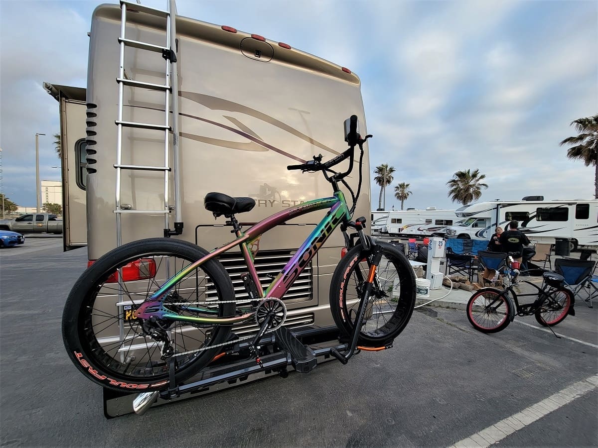 Bicycle mounted on RV at campground.