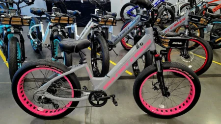 Electric bikes with pink-accented wheels displayed.