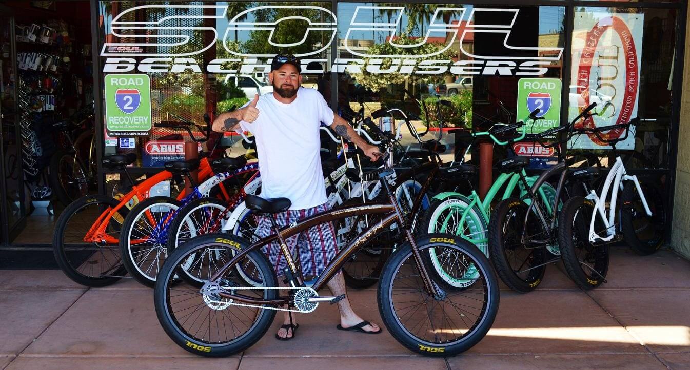 Man posing with bicycles in store entrance.