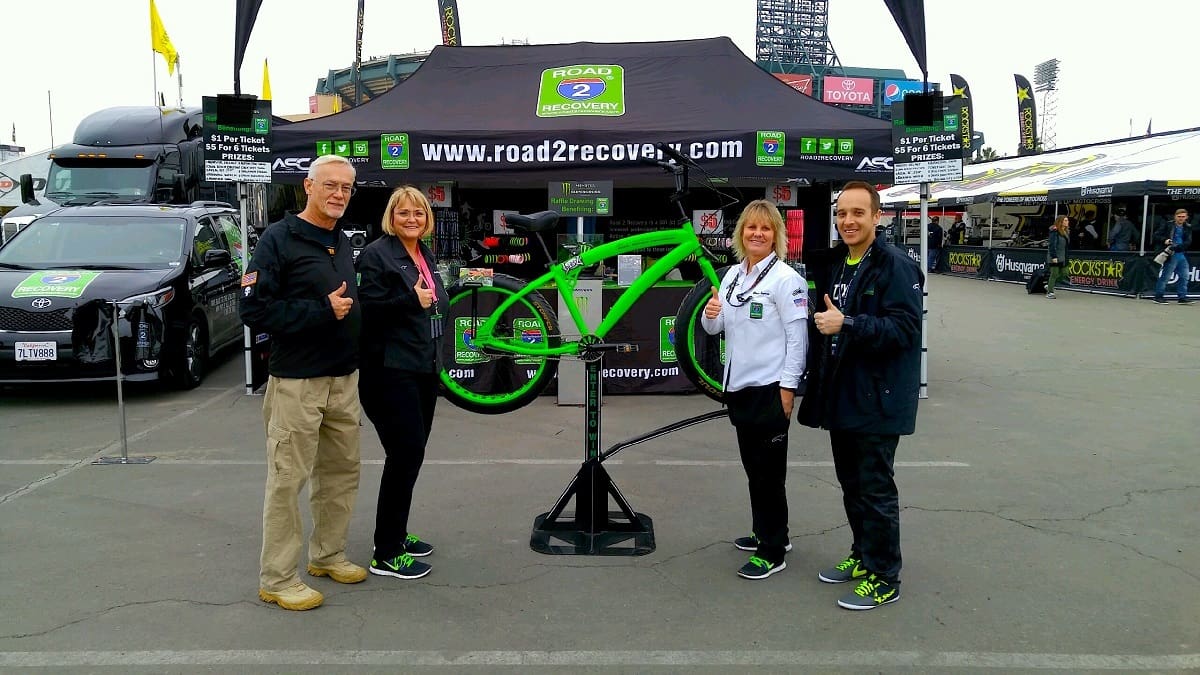 Group posing with green bike frame display.